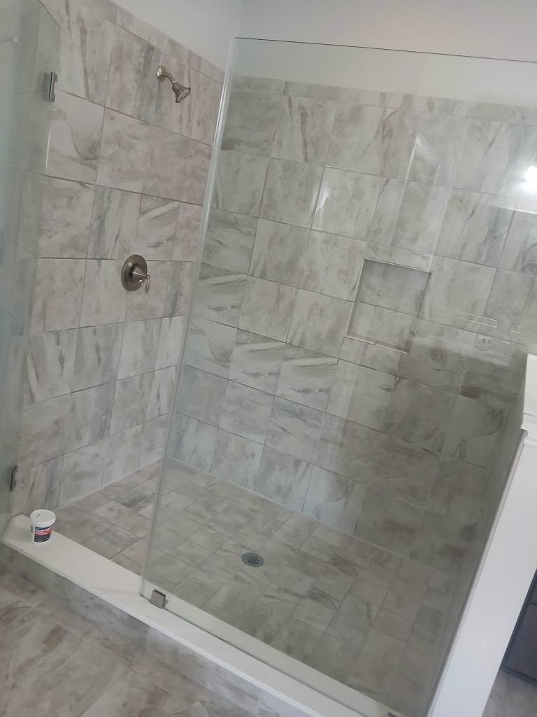 Grey stone-look tile walk-in shower with glass enclosure