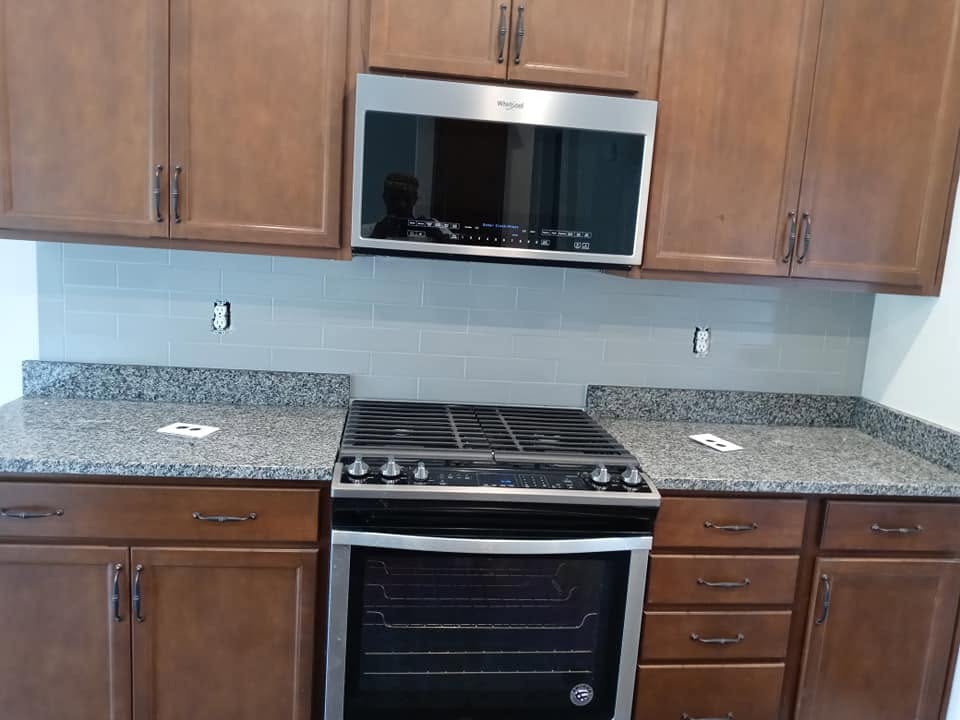 Glass subway tile backsplash with granite countertop
